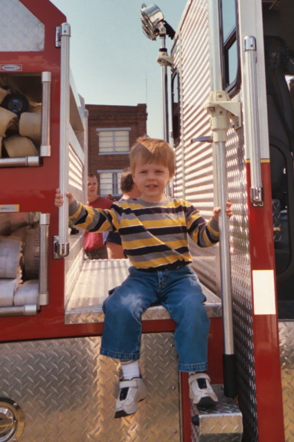 "Look at me, I'm sitting on a REAL fire truck!"